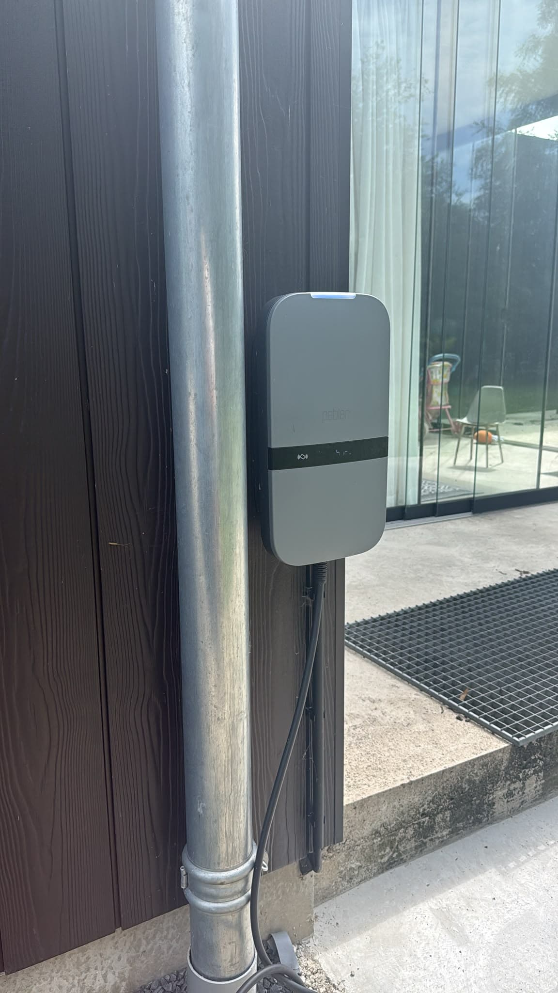 Peblar laadpaal die we plaatsten aan een moderne gevel, met de laadkabel weggewerkt
