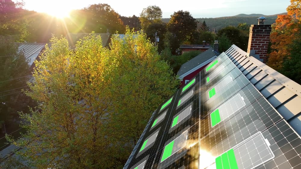 Zonnepanelen op een schuin dak tijdens zonsondergang